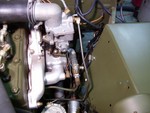 The view shows how I routed the fuel line to the carbureter to avoid vapor lock. It has been working fine during hot drives.