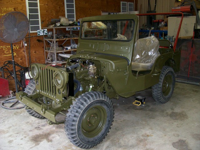 Update. May 3 2009.These next 4 pics show some progress. A previous owner had removed all the 24V equiptment and deep fording stuff and YF carb so for now it's going to run 12V and set up like a WW2/civilian jeep under the hood.Will have the fenders and hood finished and installed for the next update.